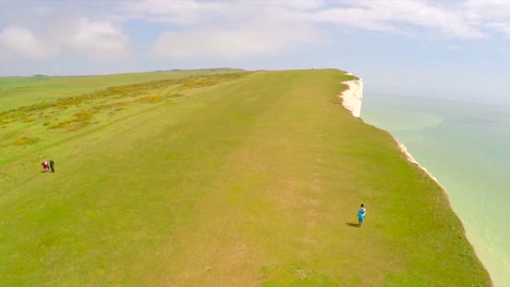 Luftaufnahme-Von-Menschen,-Die-Entlang-Der-Weißen-Klippen-Von-Dover-Am-Beachy-Head-England-Spazieren-1