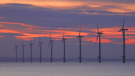 Ein-Windpark-Erzeugt-Bei-Sonnenuntergang-Strom-Entlang-Einer-Küste-4