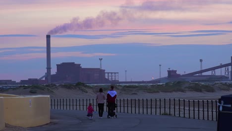 A-power-plant-emits-smoke-along-a-beach-in-England