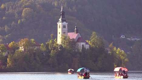 Los-Botes-De-Remos-Se-Dirigen-A-La-Isla-En-El-Lago-Bled-Eslovenia-Al-Atardecer