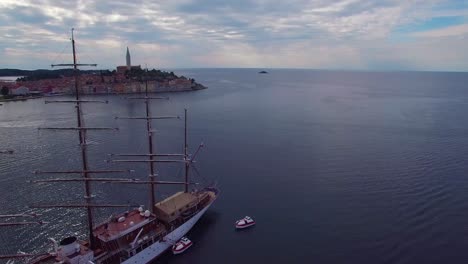 Beautiful-aerial-shot-of-the-town-of-Rovinj-in-Croatia-with-tall-ship-in-foreground-1
