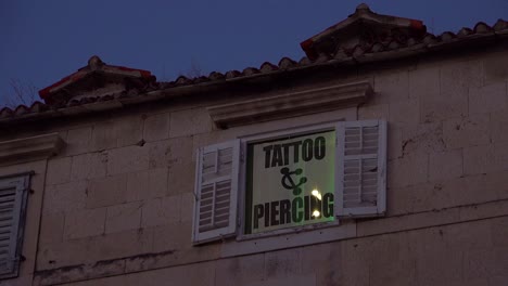 Establishing-shot-of-a-tattoo-and-piercing-studio-in-an-old-rundown-building