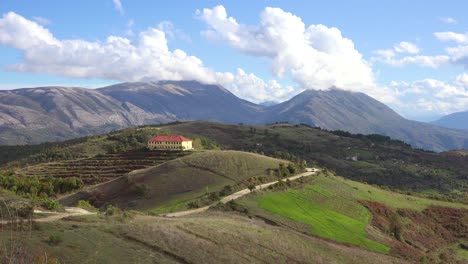 Establishing-shot-of-the-beautiful-alpine-mountains-of-Albania-with-distant-remote-building