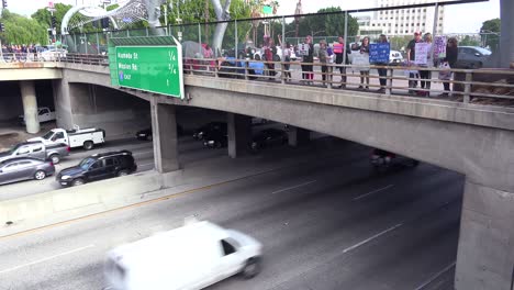 Protestors-against-Donald-Trump-stand-on-an-overpass-in-Los-Angeles-and-passing-drivers-honk-their-support