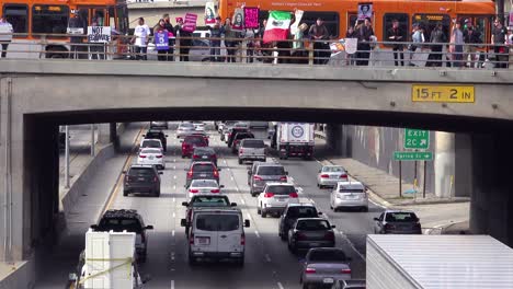 Protestors-against-Donald-Trump-stand-on-an-overpass-in-Los-Angeles-waving-Mexican-flags