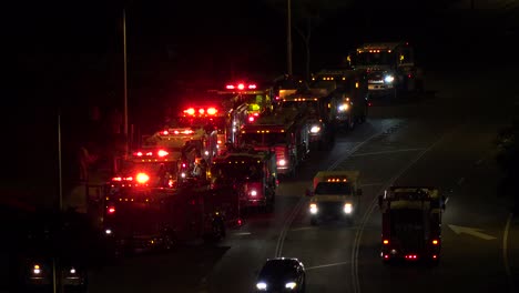 Fire-trucks-and-emergency-vehicles-are-lined-up-in-a-staging-area-at-night-during-an-emergency