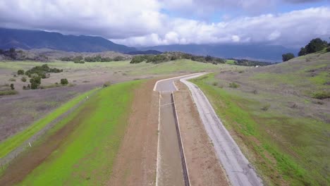 Gute-Luftaufnahme-Eines-Aquädukts,-Das-Durch-Die-Wüste-Und-Die-Berge-Kaliforniens-Fließt-2