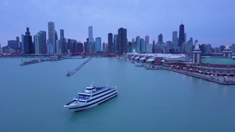 Una-Hermosa-Antena-Alrededor-Del-Navy-Pier-En-Chicago-Con-La-Noche-De-Fondo-Del-Horizonte-De-La-Ciudad