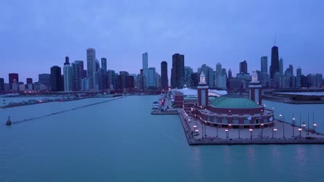 Una-Hermosa-Antena-Alrededor-Del-Navy-Pier-En-Chicago-Con-El-Horizonte-De-La-Ciudad-De-Fondo-La-Noche-1