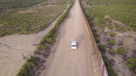 Vista-Aérea-over-a-border-patrol-vehicle-standing-guard-near-the-border-wall-at-the-US-Mexico-border-4