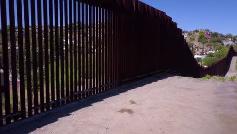 Slow-rising-aerial-along-the-US-Mexican-border-wall-fence-reveals-the-town-of-Nogales
