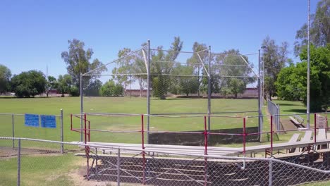 Un-Tiro-Ascendente-Sobre-Un-Campo-De-Béisbol-Muestra-El-Muro-Fronterizo-De-Estados-Unidos-Y-México-En-El-Fondo