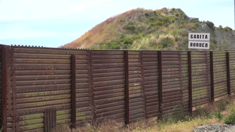 Der-Us-Mexiko-Grenzmauerzaun-Mit-Einem-Schild-Mit-Der-Schrift-Grenze-Im-Hintergrund-1