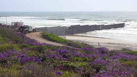 Ein-Grenzpatrouillenfahrzeug-Schaut-Zu,-Wie-Die-Wellen-Am-US-Mexiko-Grenzzaun-Im-Pazifischen-Ozean-Zwischen-San-Diego-Und-Tijuana-In-Den-Strand-Rollen