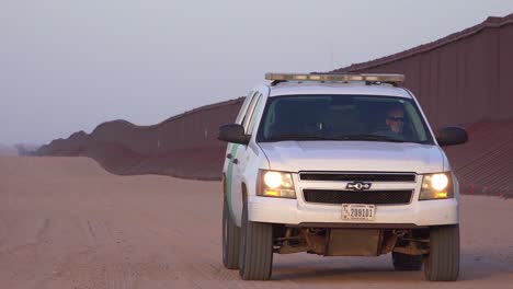 Border-patrol-vehicle-moves-slowly-near-the-border-wall-at-the-US-Mexico-border-at-Imperial-sand-dunes-California-2