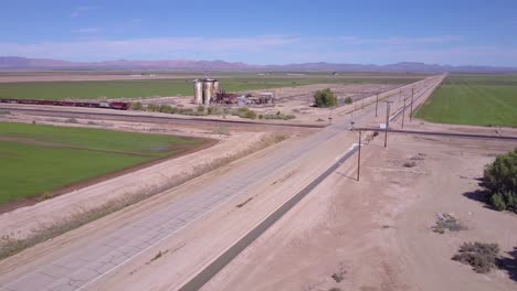 Una-Antena-De-Alto-ángulo-Sobre-Una-Carretera-Abandonada-Solitaria-A-Través-De-Una-Intersección-Rural