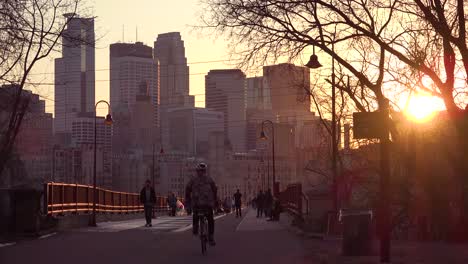 Beautiful-shot-of-pedestrians-walking-at-sunset-with-the-Minneapolis-Minnesota-skyline-background