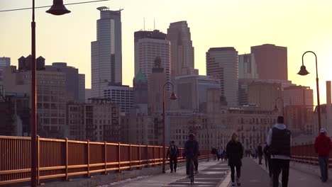 Beautiful-shot-of-pedestrians-walking-at-sunset-with-the-Minneapolis-Minnesota-skyline-background-1