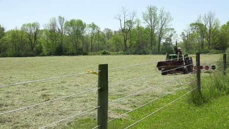 Ein-Freundlicher-Amerikanischer-Bauer-Fährt-Seinen-Traktor,-Während-Er-Seine-Felder-Pflügt