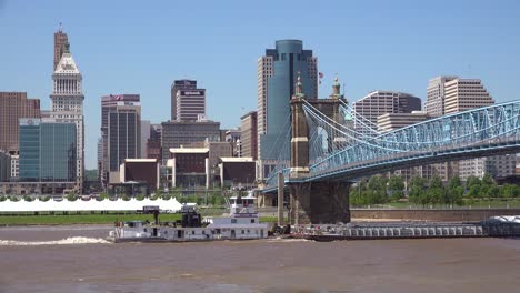 An-establishing-shot-of-Cincinnati-Ohio-with-a-barge-on-the-Ohio-River