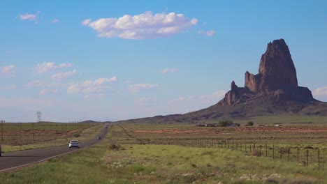 Cars-drive-along-a-highway-near-Monument-Valley-with-beautiful-rock-formations-nearby