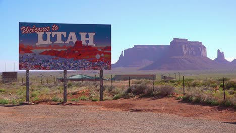 Un-Cartel-Da-La-Bienvenida-A-Los-Visitantes-A-Utah-Con-El-Fondo-Del-Valle-Del-Monumento