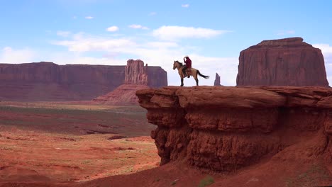 A-cowboy-sits-on-a-horse-on-a-cliff-in-Monument-Valley-Utah-1