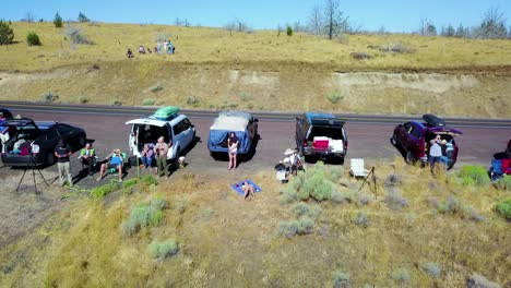 An-aerial-perspective-of-people-watching-a-solar-eclipse-along-a-highway-or-road