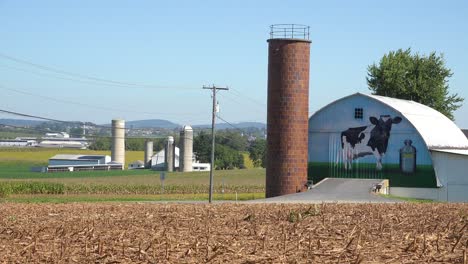Establishing-shot-of-a-dairy-farm-with-large-cow-painted-on-barn