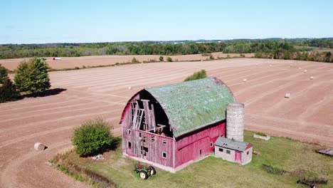 An-aerial-shot-goes-around-a-barn-on-a-farm