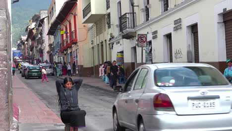 A-woman-sits-on-the-streets-of-Quito-Ecuador-as-traffic-passes