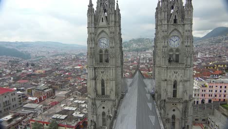 Pan-across-rooftop-shot-of-the-Basicala-Del-Voto-Nacional-in-Quito-Ecuador-with-city-background