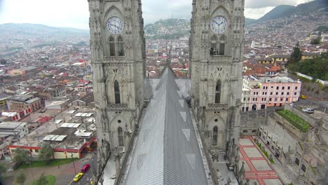 Tilt-up-rooftop-shot-of-the-Basicala-Del-Voto-Nacional-in-Quito-Ecuador-with-city-background