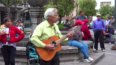 Ein-Mann-Spielt-Gitarre-In-Einem-Park-In-Der-Innenstadt-Von-Quito-Ecuador-Während-Der-Mittagspause