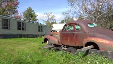 An-abandoned-car-sits-on-blocks-outside-a-trailer-home-in-rural-America-1