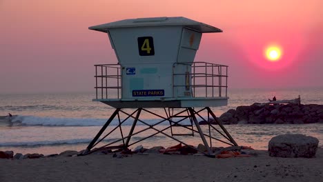 A-sunset-behind-a-lifeguard-station-along-a-California-beach-2