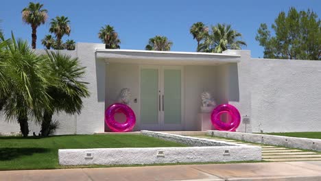 Establishing-shot-of-a-classic-mid-century-modern-deco-style-home-in-Palm-Springs-California-with-pink-innertubes-in-entry-way