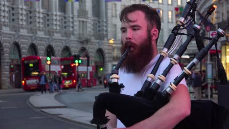 A-Scottish-bagpiper-performs-on-the-street-near-London's-Piccadilly-Square
