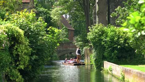 Boats-are-rowed-down-a-canal-in-Canterbury-Kent-England