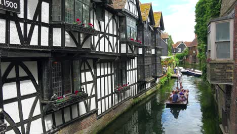 Boote-Werden-Einen-Kanal-Entlang-Gerudert,-Umgeben-Von-Schöner-Architektur-In-Canterbury,-Kent-England