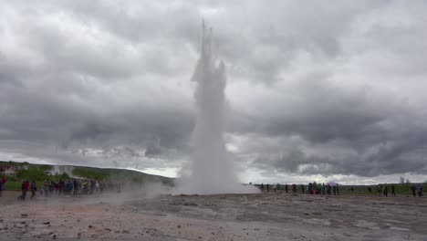 El-Famoso-Géiser-Strokkur-Geysir-De-Islandia-Entra-En-Erupción-Con-Turistas-Viendo-1