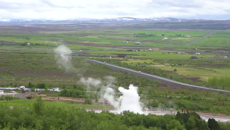 El-Famoso-Géiser-Strokkur-Geysir-De-Islandia-Entra-En-Erupción-Con-La-Campiña-Islandesa-De-Fondo