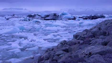 Pan-A-Través-De-Icebergs-Sentado-En-Una-Bahía-Glaciar-Sugiriendo-El-Calentamiento-Global-En-El-Ártico-En-La-Laguna-Glaciar-Jokulsarlon-Islandia-Noche