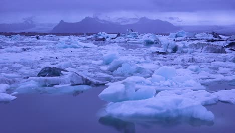 Pan-A-Través-De-Icebergs-Sentado-En-Una-Bahía-Glacial-Sugiriendo-El-Calentamiento-Global-En-El-Ártico-En-La-Laguna-Glaciar-Jokulsarlon-Islandia-Noche-1