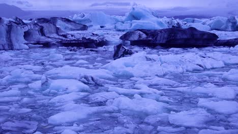 Inclinarse-Hacia-Los-Icebergs-Sentado-En-Una-Bahía-Glacial-Que-Sugiere-El-Calentamiento-Global-En-El-Ártico-En-La-Laguna-Glaciar-Jokulsarlon-Islandia-Noche