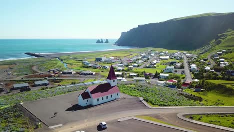 Aerial-establishing-shot-of-the-town-of-Vik-in-Southern-Iceland-its-iconic-church