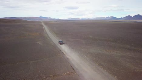 Very-good-aerial-of-a-black-van-traveling-on-a-dirt-road-across-the-highland-interior-of-Iceland-5