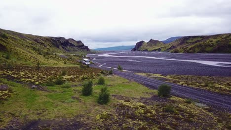 Antenne-über-Einen-Bus,-Der-Neben-Einem-Fluss-Im-Hochland-Von-Island-Fährt