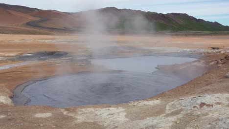 A-bubbling-mud-pool-in-a-geothermal-area-along-a-road-near-Myvatn-Iceland