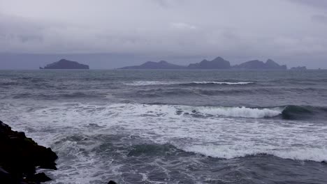 Establishing-shot-of-the-Westmann-Islands-in-Iceland-with-a-stormy-dark-sea-foreground